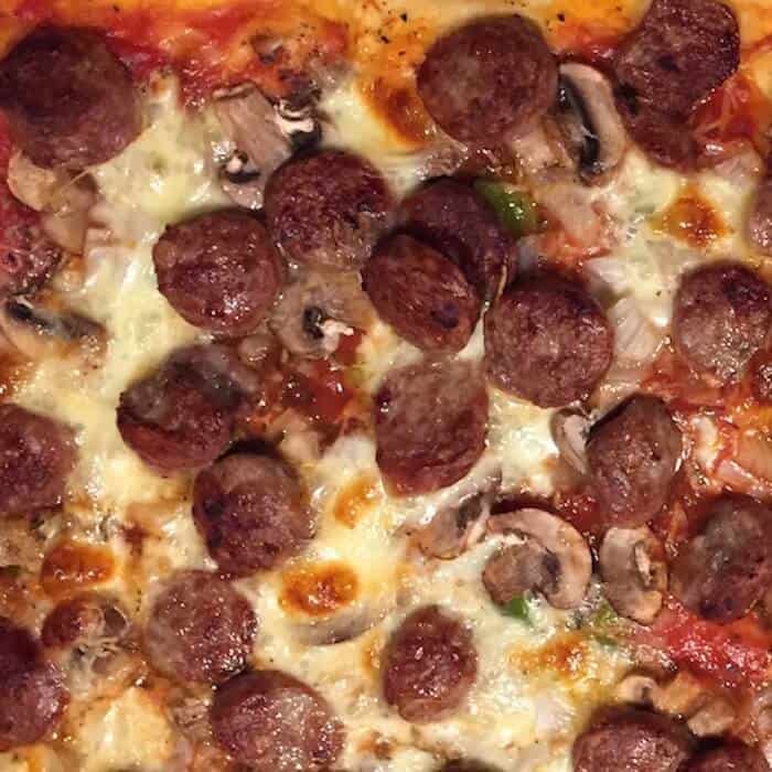 Homemade Pizza with sausage on a homemade pizza crust.