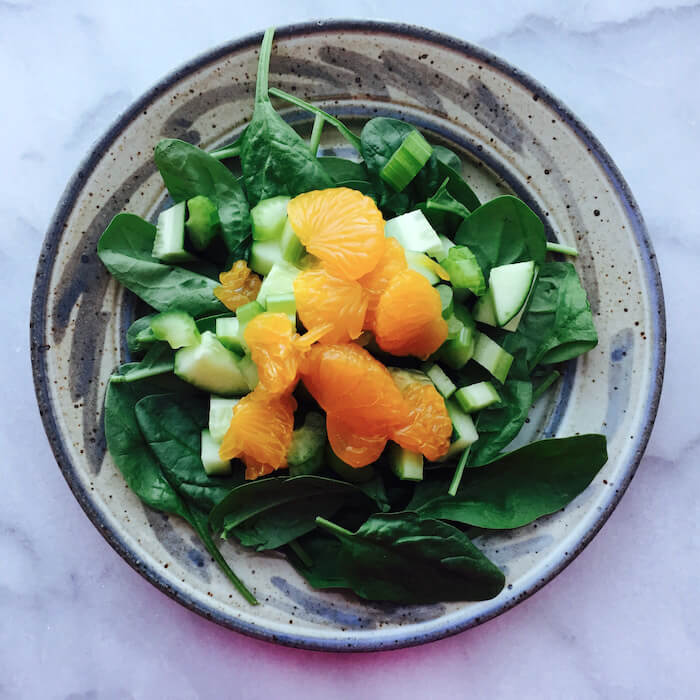Crunchy Spinach Salad is comprised of spinach, Mandarin oranges, celery and cucumbers.