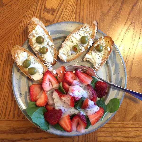 This Simple Strawberry Spinach Salad Recipe with Brianna's Poppyseed Dressing is shown with Gluten Free Dairy Free White Bread, goat cheese and olives. Add a glass of wine for a lovely lunch. #strawberryspinachsalad #simplestrawberryspinachsalad #sitdownandrelax