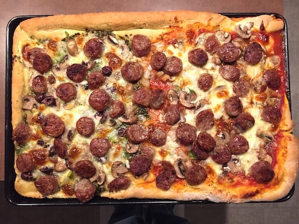 Rolled Crust Pizza made half with red sauce; half with pesto