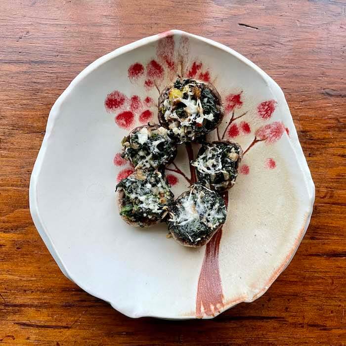 Spinach Stuffed Mushrooms shown on a plate made by potter Kary Haun.