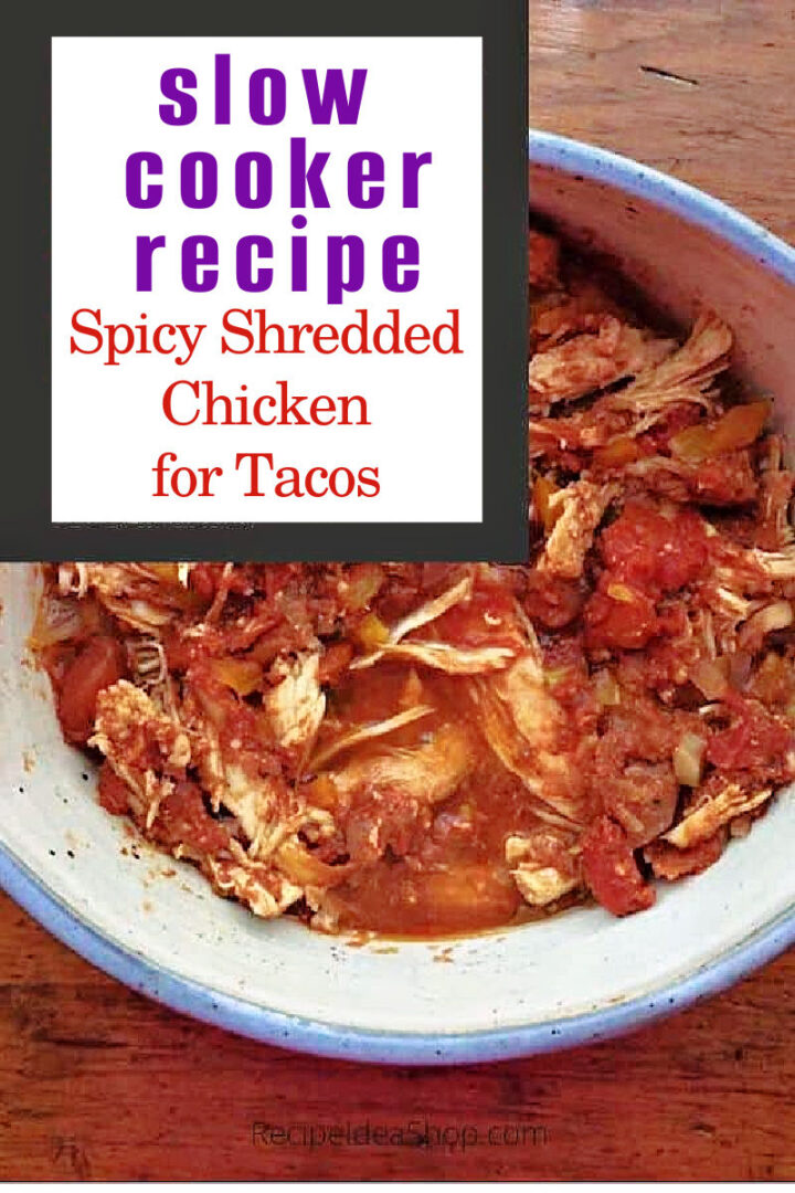 A bowl of Spicy Shredded Chicken and tomatoes sits on a wooden surface. Text above reads: slow cooker recipe - Spicy Shredded Chicken for Tacos.