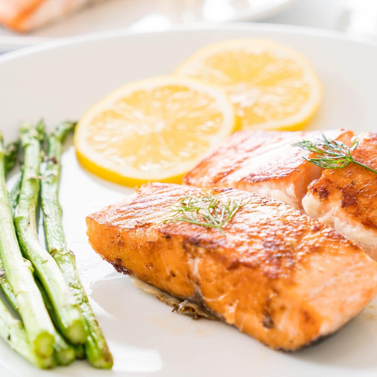 Baked salmon and asparagus on a white plate