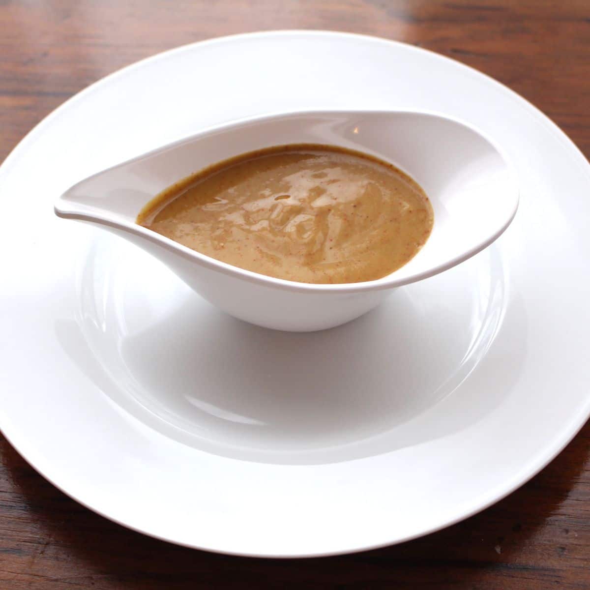 Spicy mustard sauce in a pretty white dish.