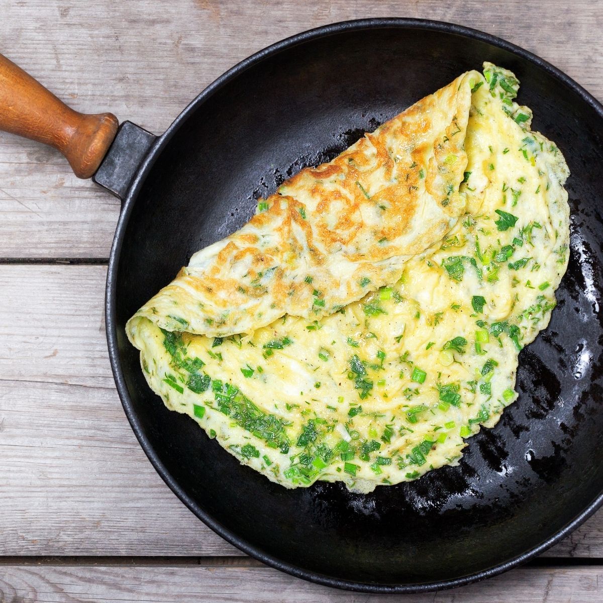 omelet with herbs in a frying pan