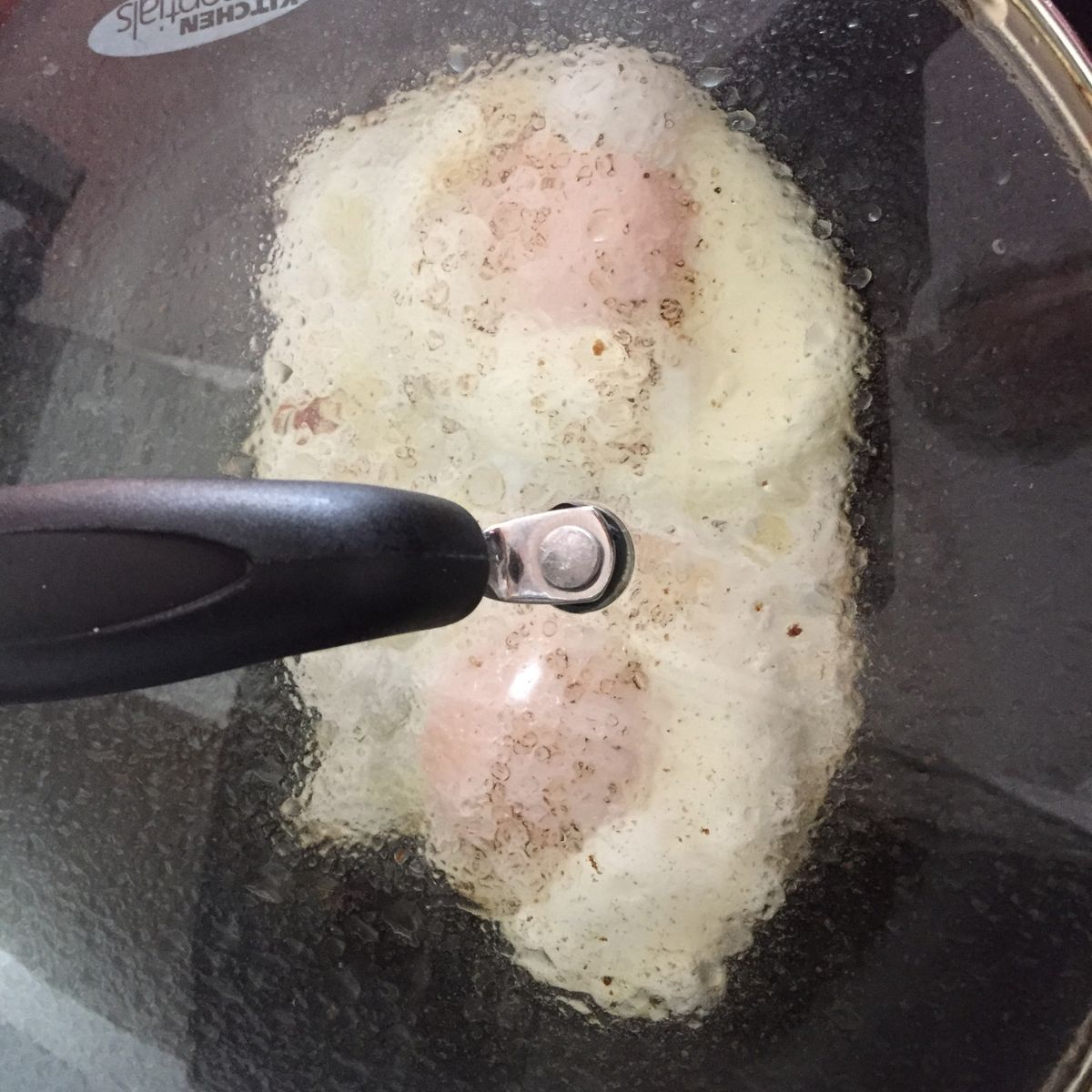 Eggs basting in a covered skillet.