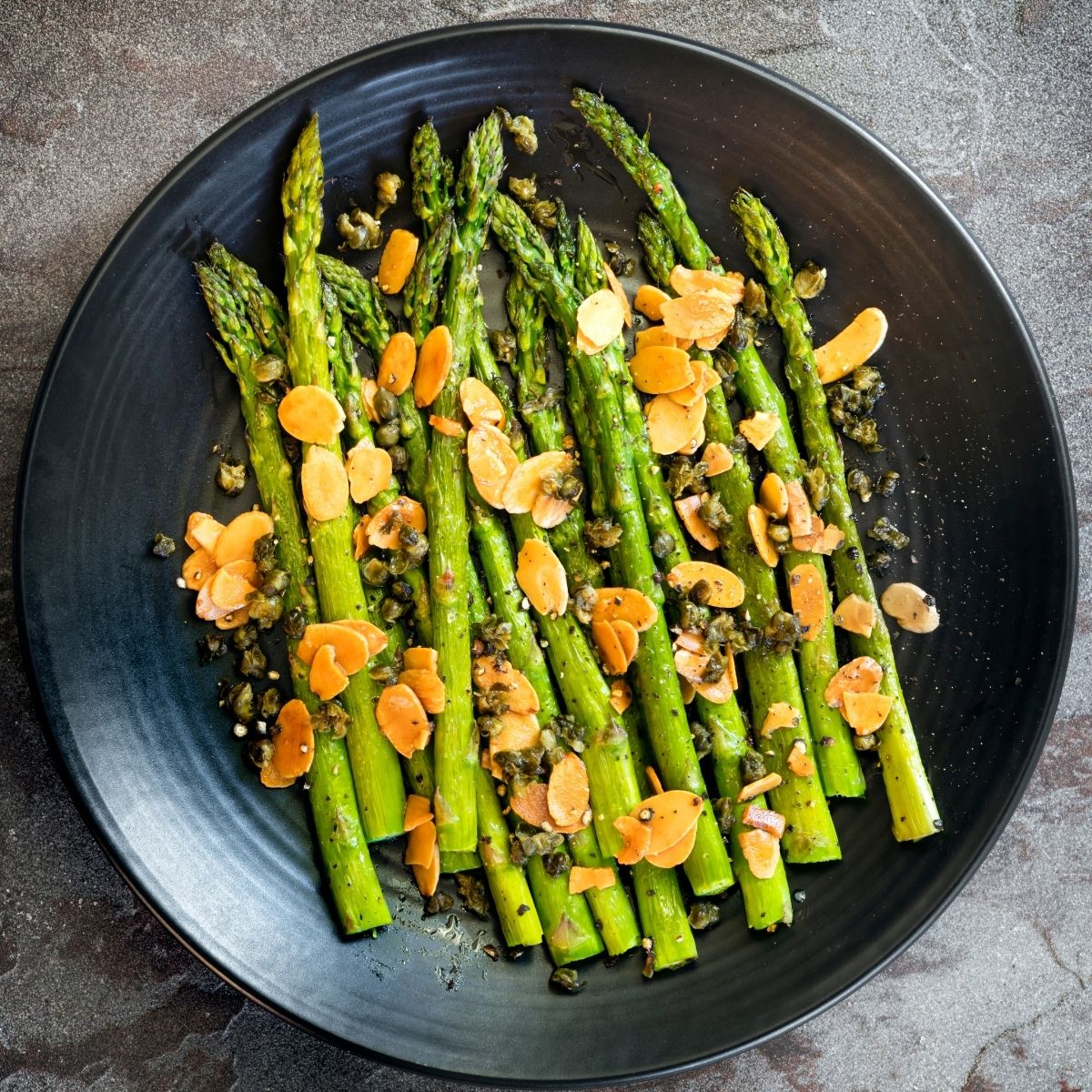 roasted asparagus and almonds in black bowl
