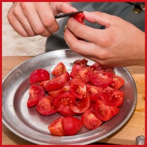 hands peeling tomatoes