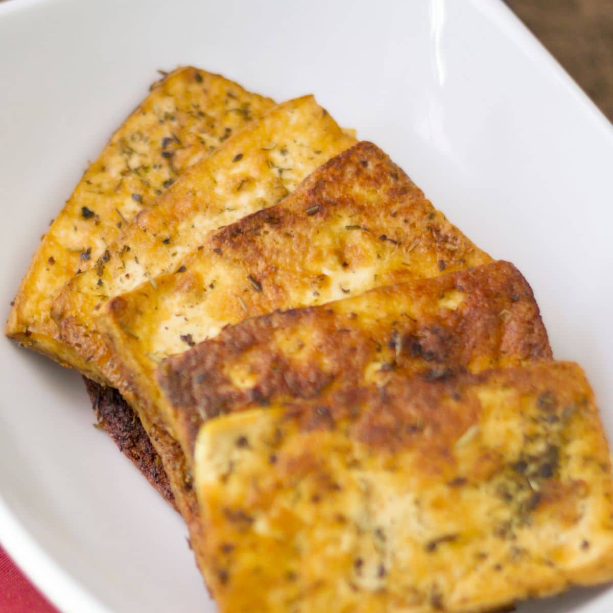 crispy tofu slices on a white plate