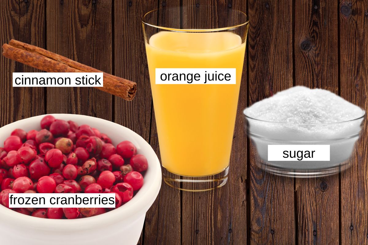 ingredients for making jellied cranberry sauce: cinnamon stick, orange juice, sugar and frozen cranberries.