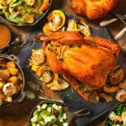 Roasted turkey on the Thanksgiving tablewith lots of colorful side dishes.