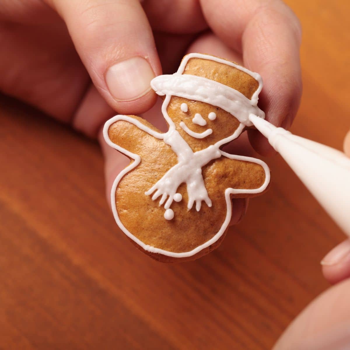 Decorating a snowman ginger cookie.