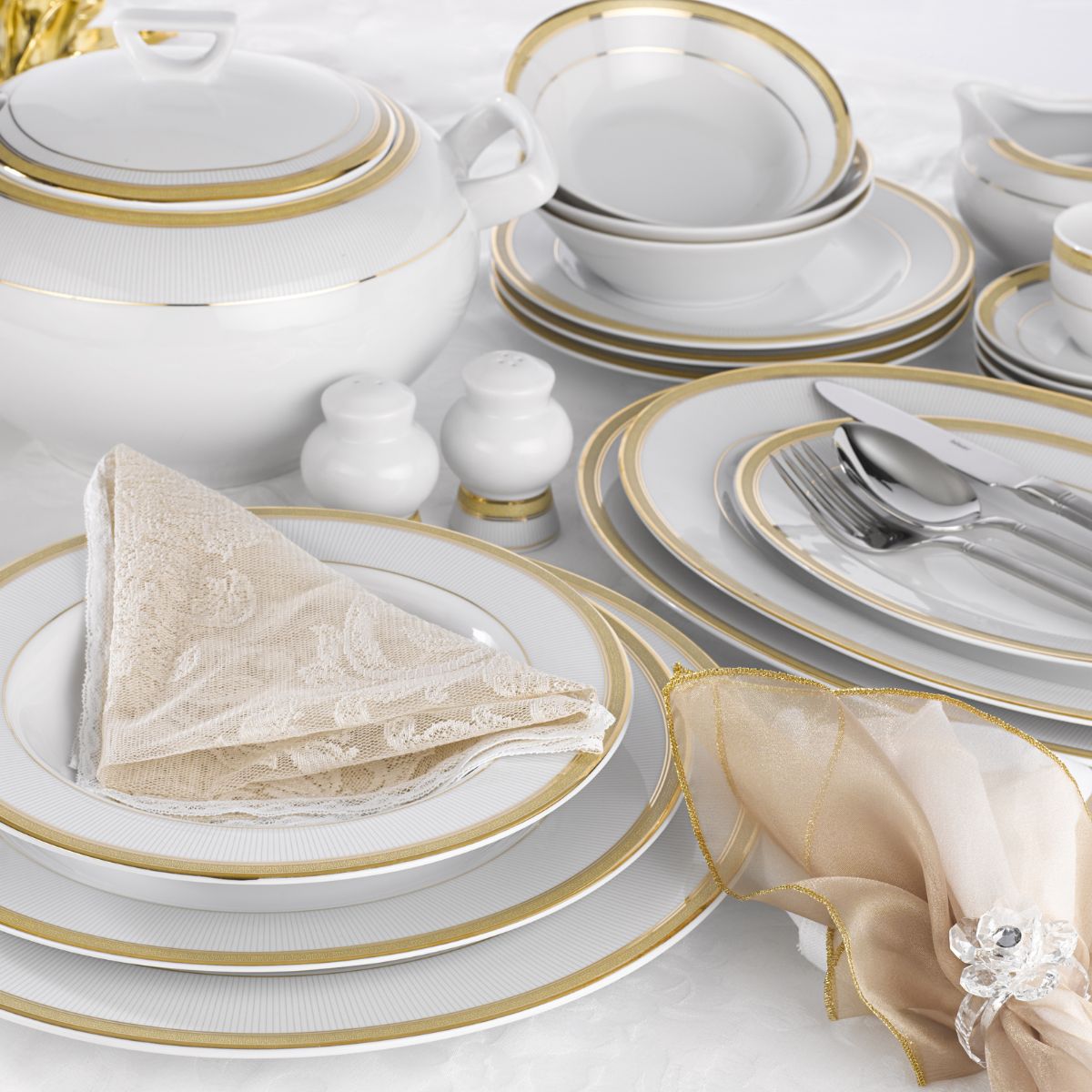 Set of white dinnerware with gold edging.