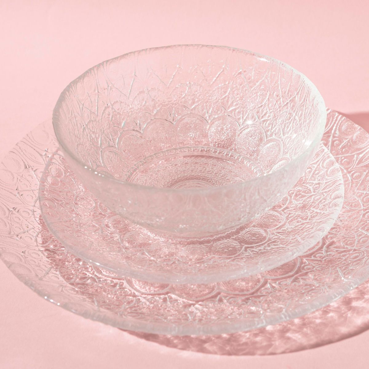 Glass dish set sitting on a pink tablecloth.