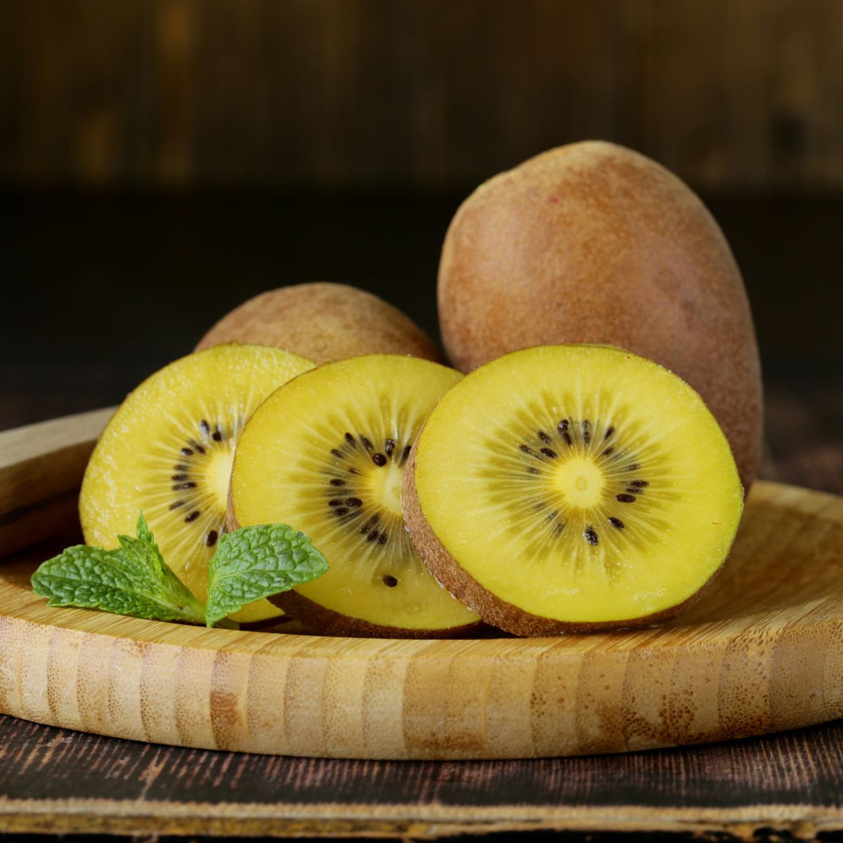 Golden kiwi fruit on a wooden plate