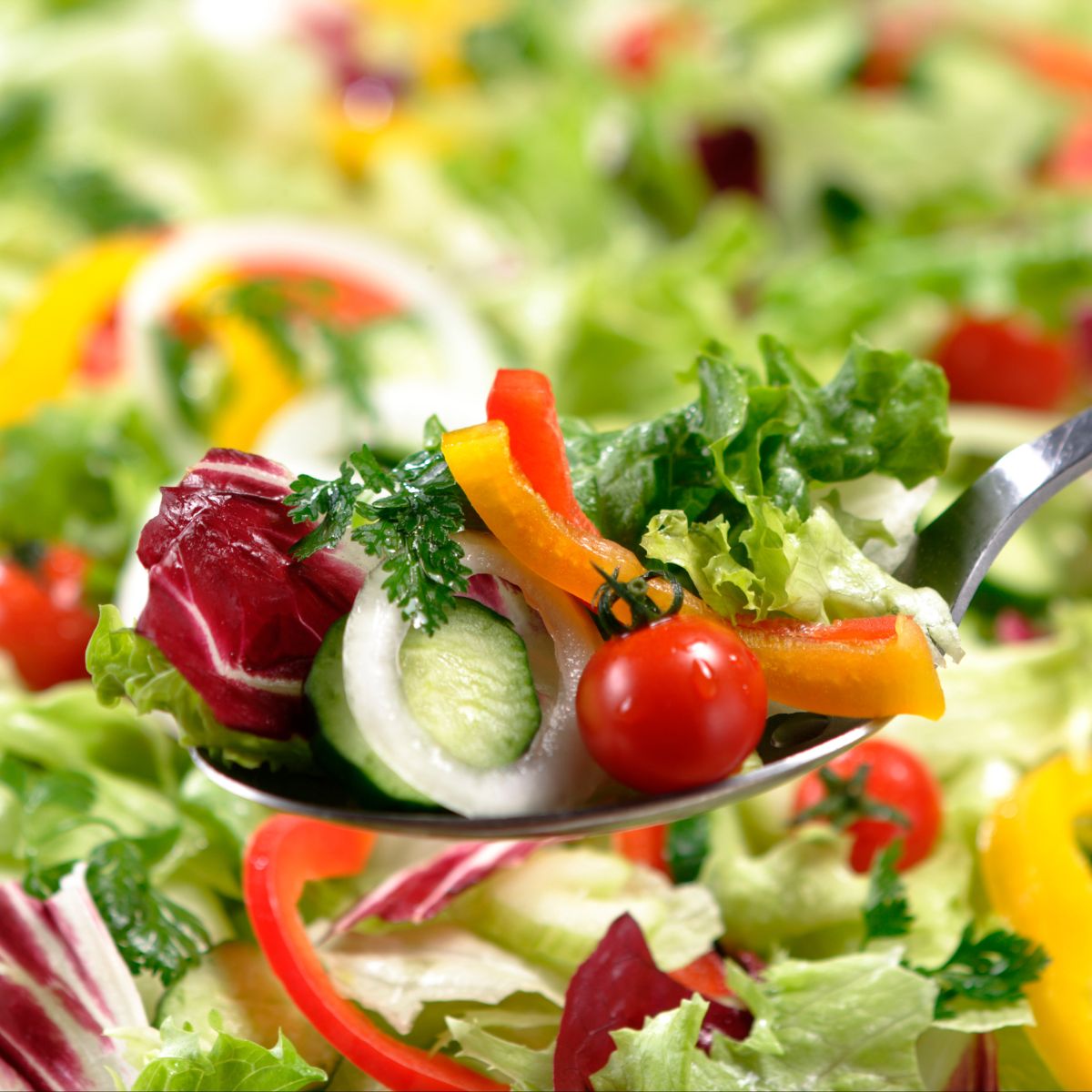 Fresh green salad with tomatoes, peppers, cucumbers, and more.