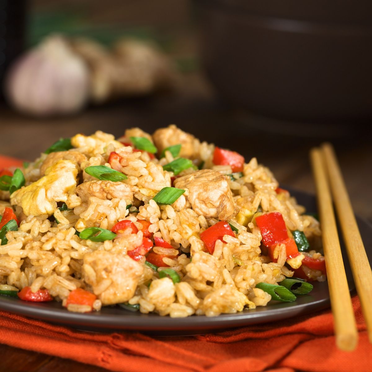 A plate of fried rice and chopsticks. 