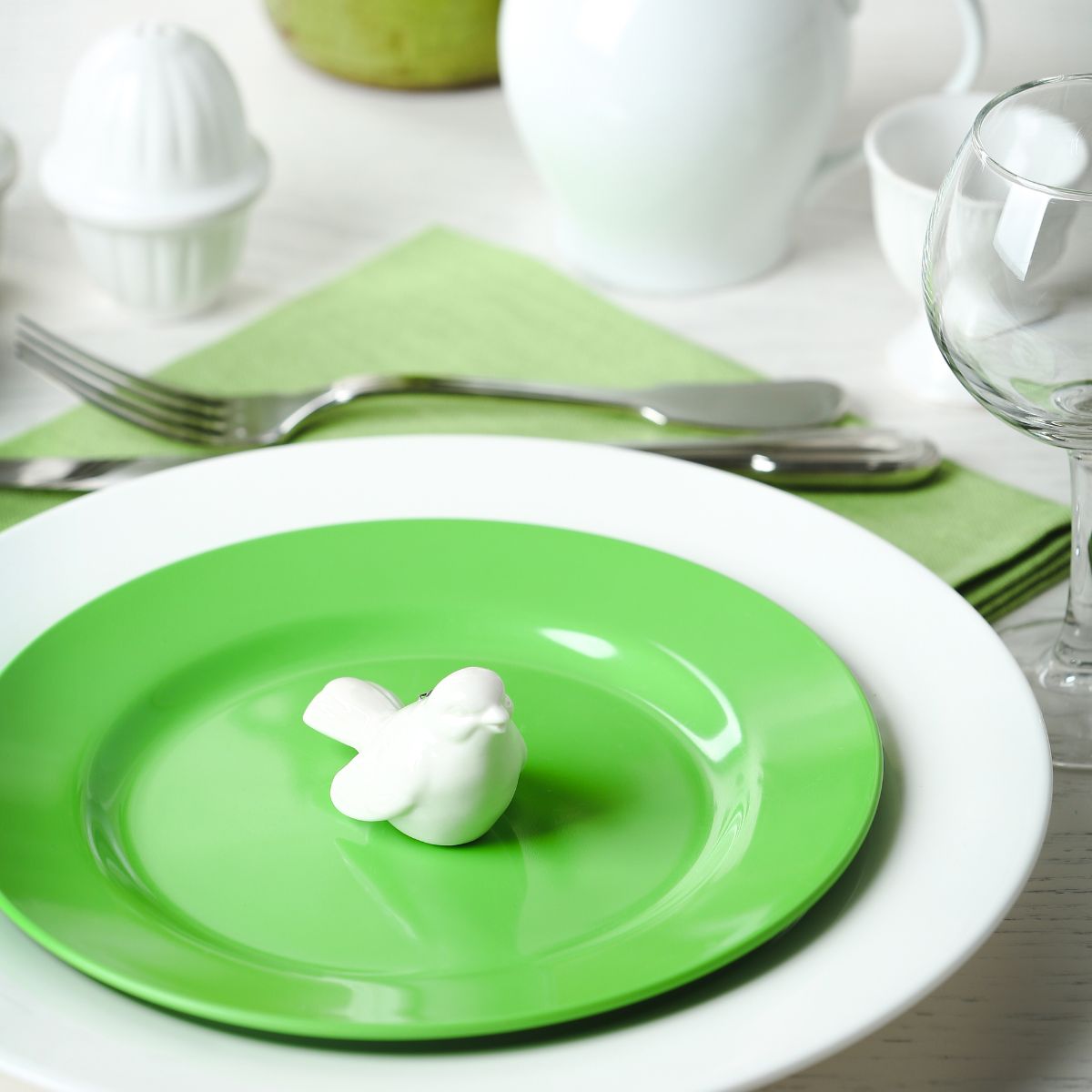 Dinner setting in white and green with a melamine plate.