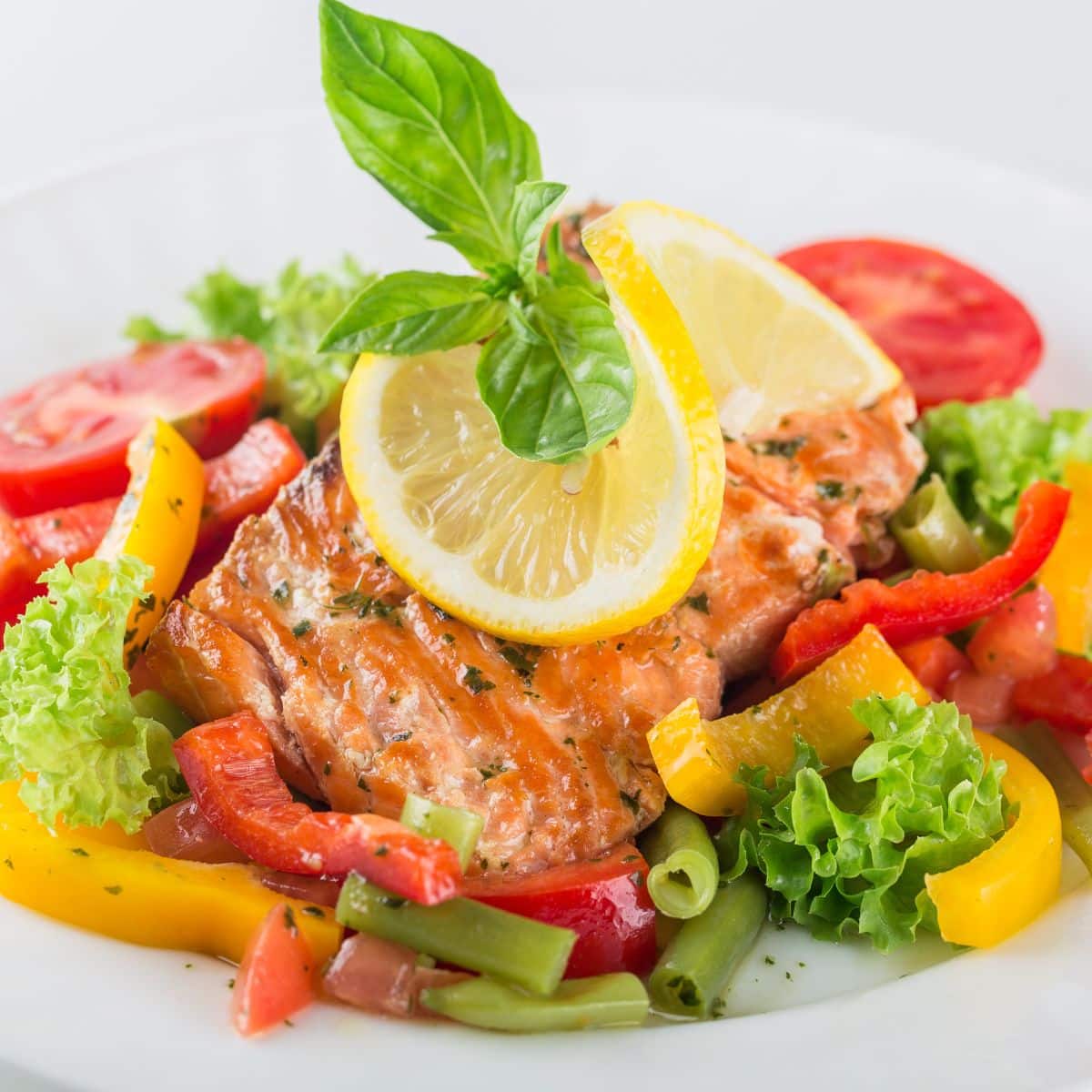 Lemon salmon wiht a brighlty colored salad.