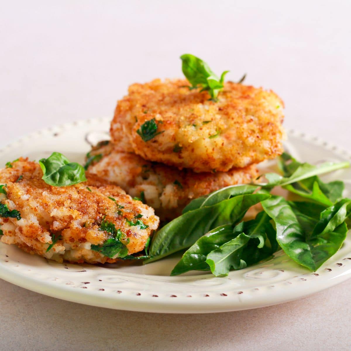 Rice fritters and spinach on and antique plate.