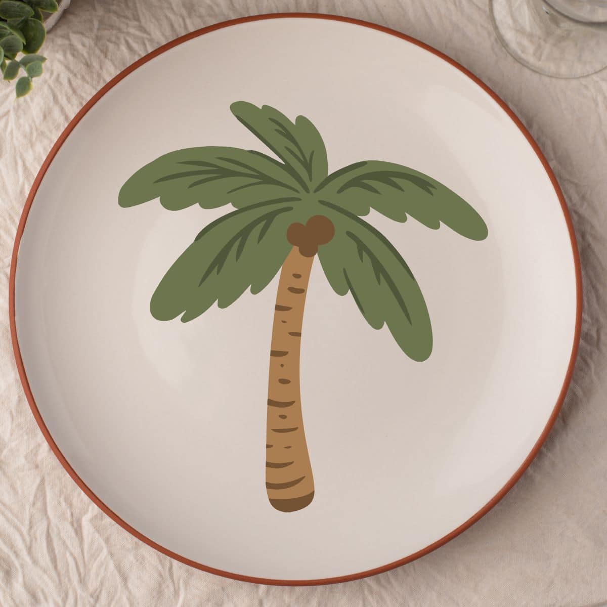 a tan colored plate with a palm tree design.