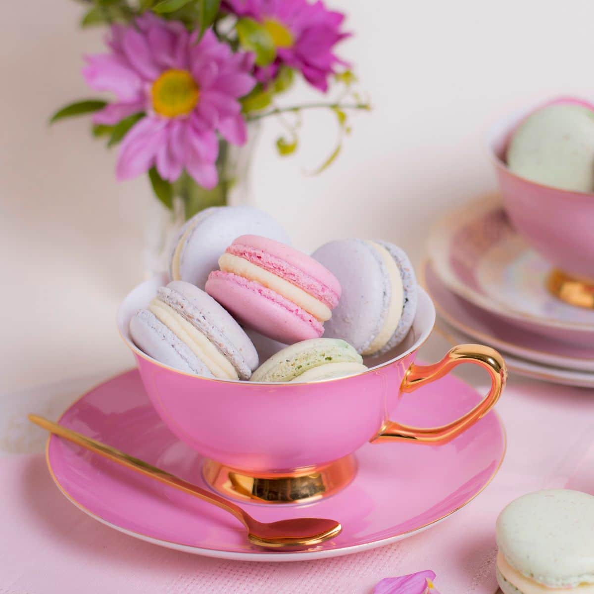 Pink cup and saucer, trimmed with gold and filled with delicious pastel colored macaroons. 