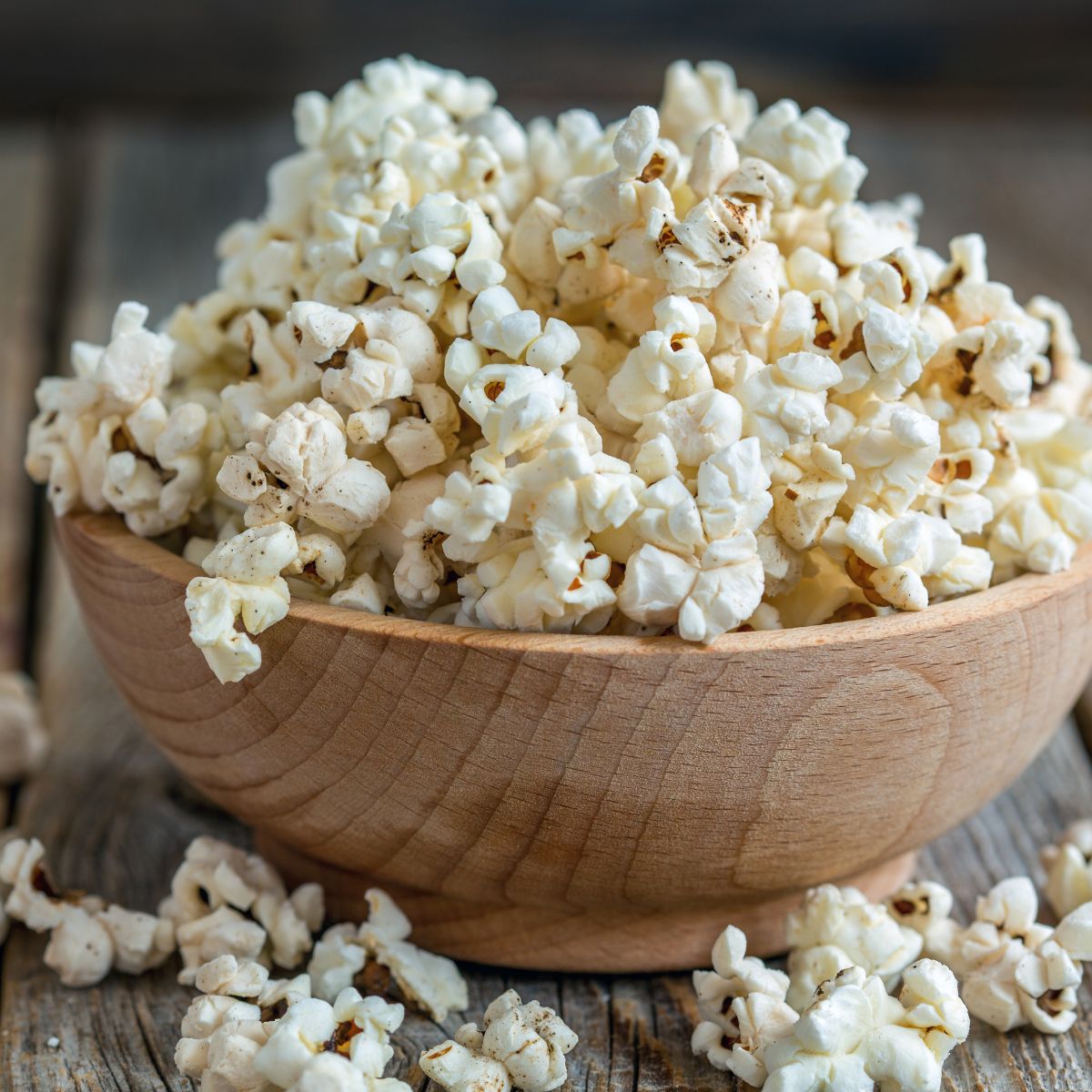 a wooden bowl filled with air-popped popcorn.