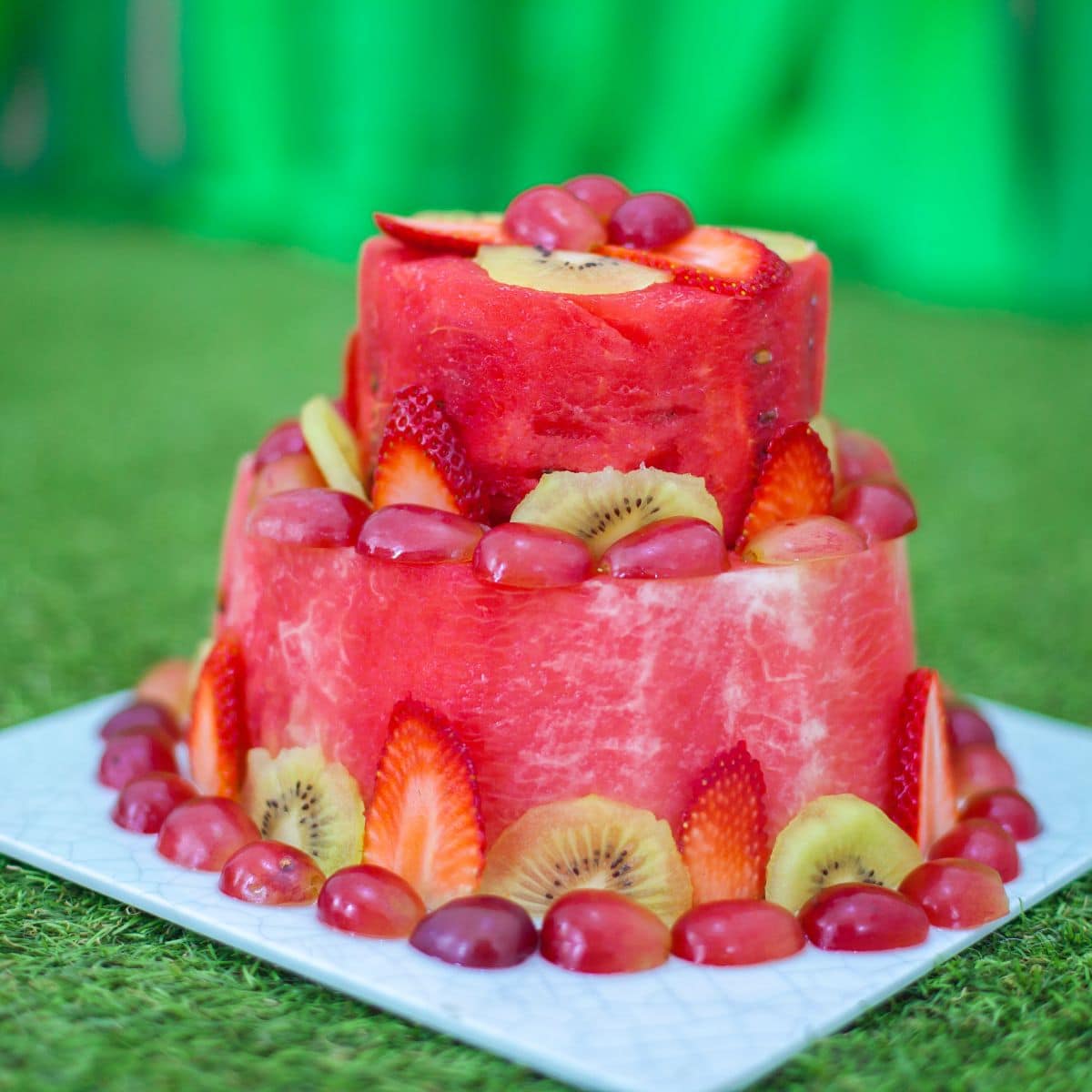 Watermelon cake with red grapes, strawberries and kiwi.