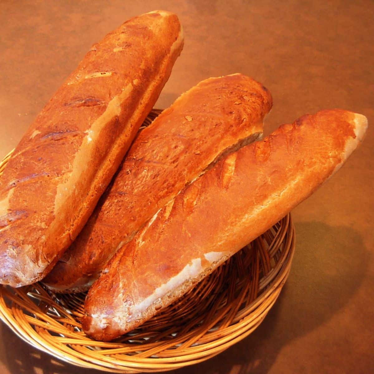 Three loaves of French bread in a basket.