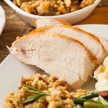 thanksgiving dinner plate with turkey slices, stuffing and beans.
