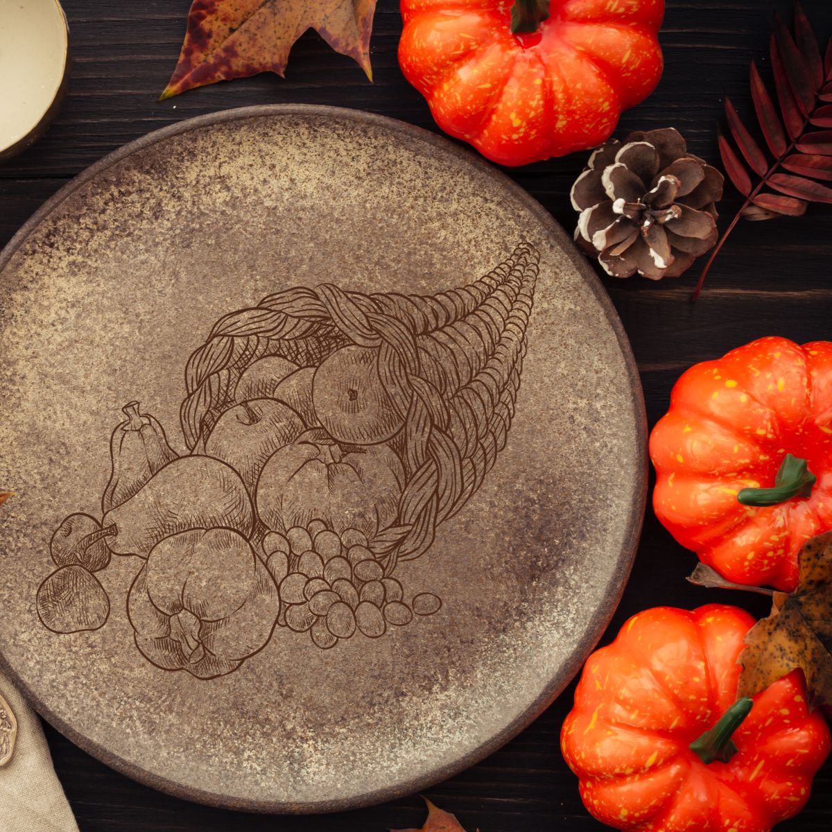 Speckled brown plate with a harvest basket design, and a few small pumpkin decorations around. 