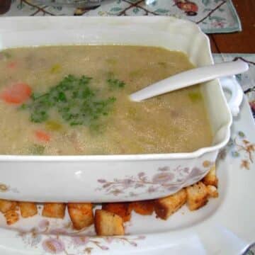 Leek and potato soup in a square dish and homemade croutons.