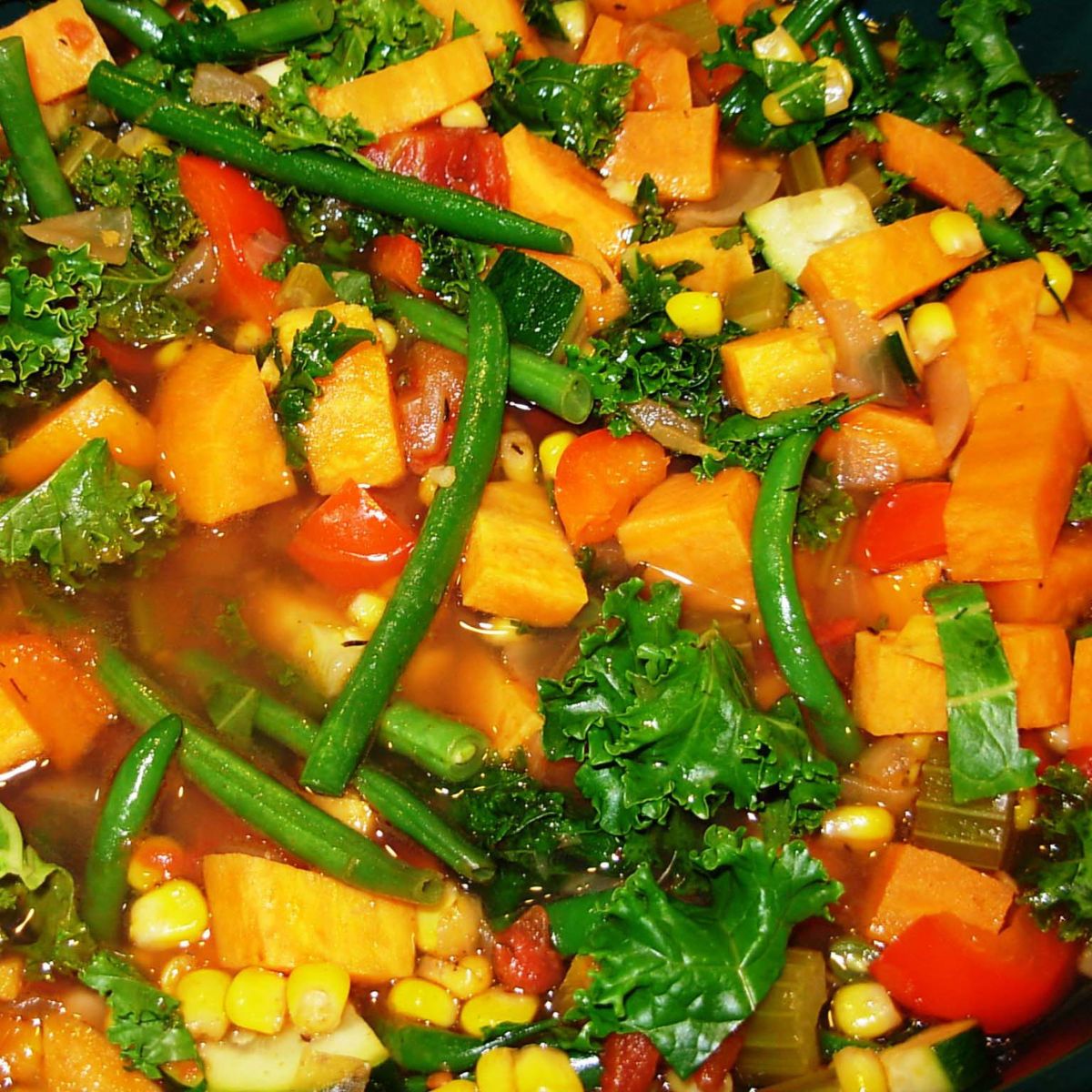 Brightly colored stew made with green beans, corn, carrots, red peppers, zucchini, and more. 