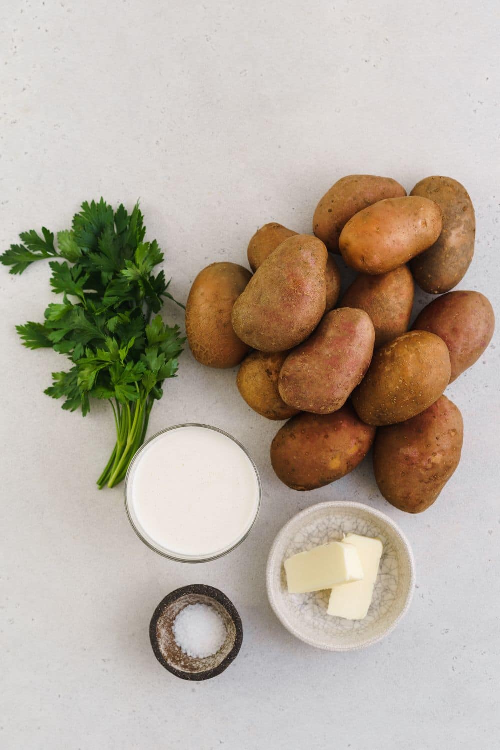 Ingredients for mashed potatoes: half and half, potatoes, butter, salt, and fresh parsley.