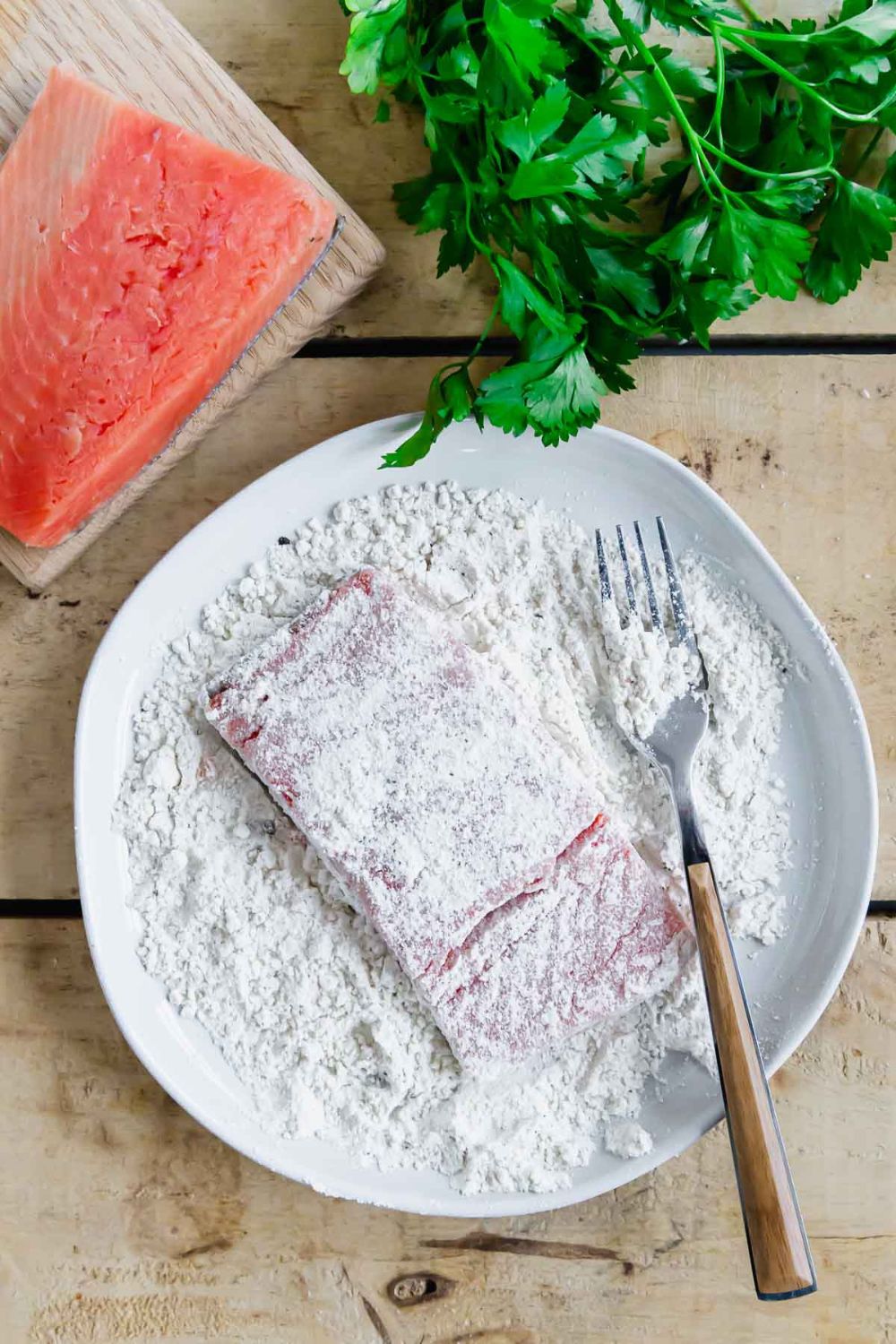 covering salmon filet with flour mixture. 