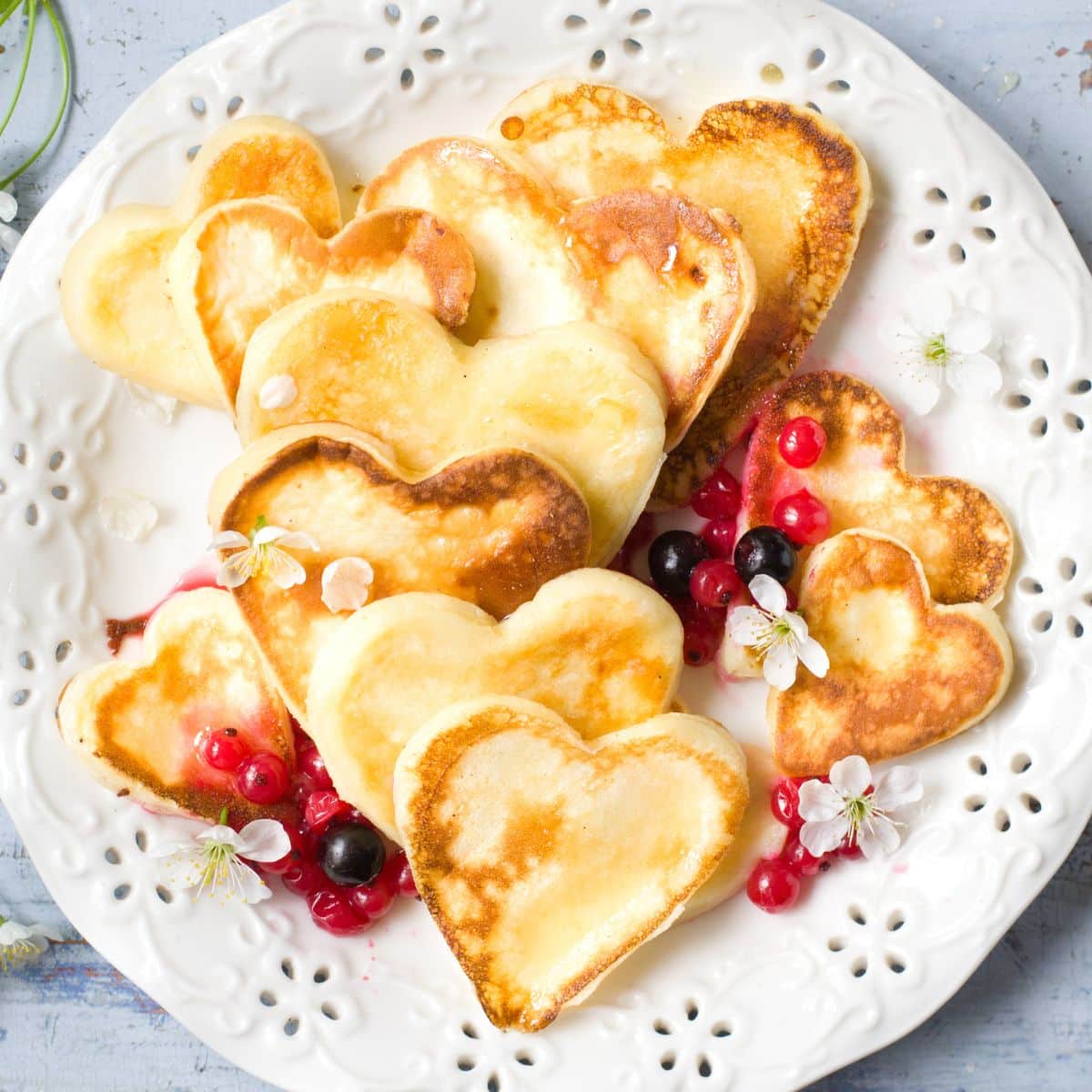 Heart shaped pancakes on a white platter.
