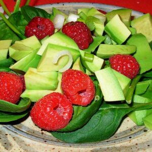 Spinach salad with avocado and raspberries.