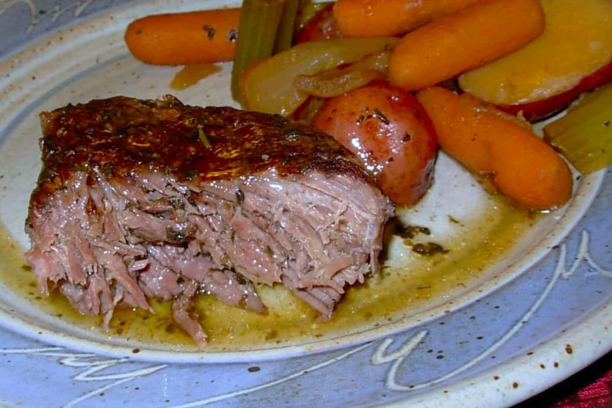 A plate with a serving of tender Winter Pot Roast, featuring baby carrots, red potatoes, celery, and onions in savory gravy—an inviting beef roast recipe perfect for chilly evenings. A plate with a serving of tender Winter Pot Roast, featuring baby carrots, red potatoes, celery, and onions in savory gravy—an inviting beef roast recipe perfect for chilly evenings.