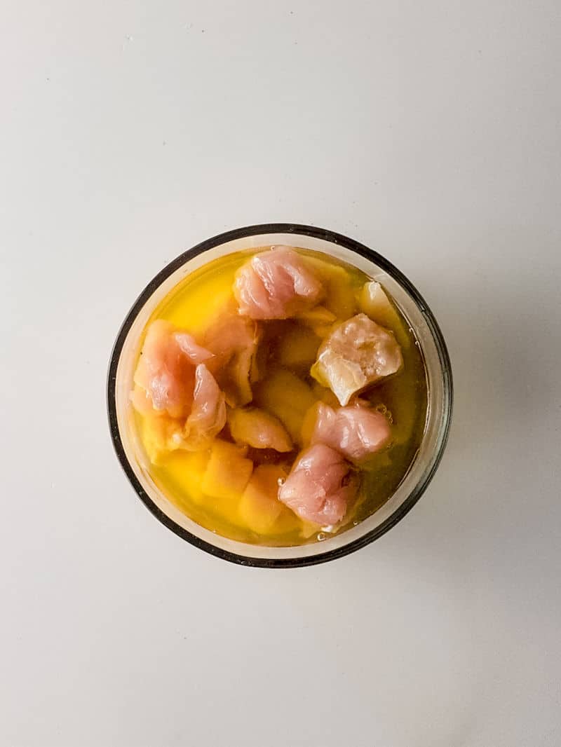 placing cut chicken in glass bowl