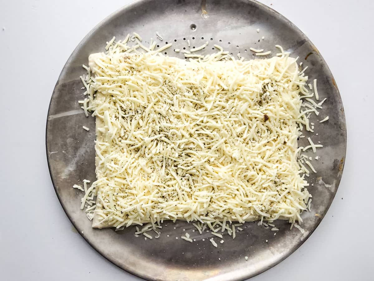 adding parmesan cheese on dough