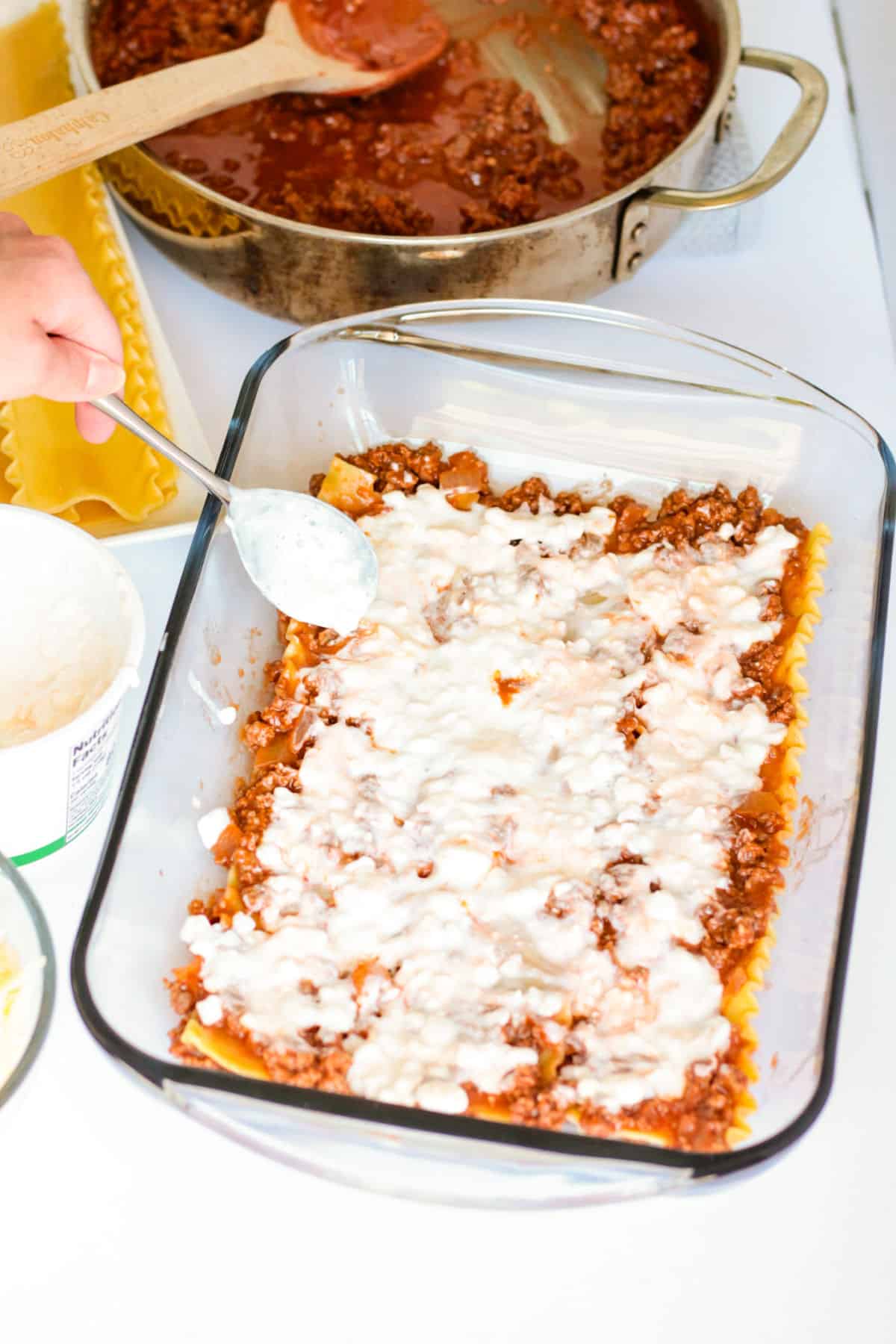 adding top layer of cheese to lasagna