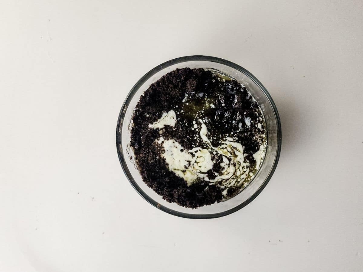 mixing oreos with melted butter for cheesecake crust
