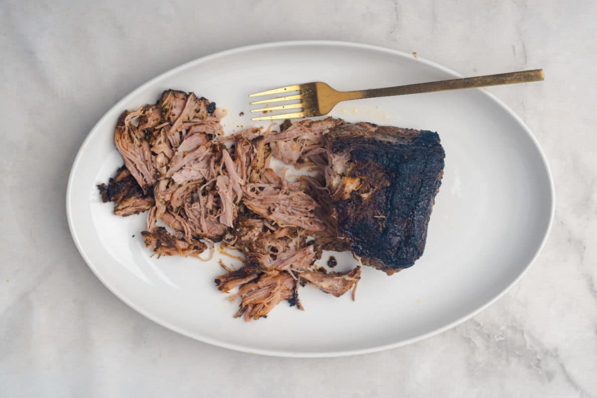 using a fork to shred cooked pork
