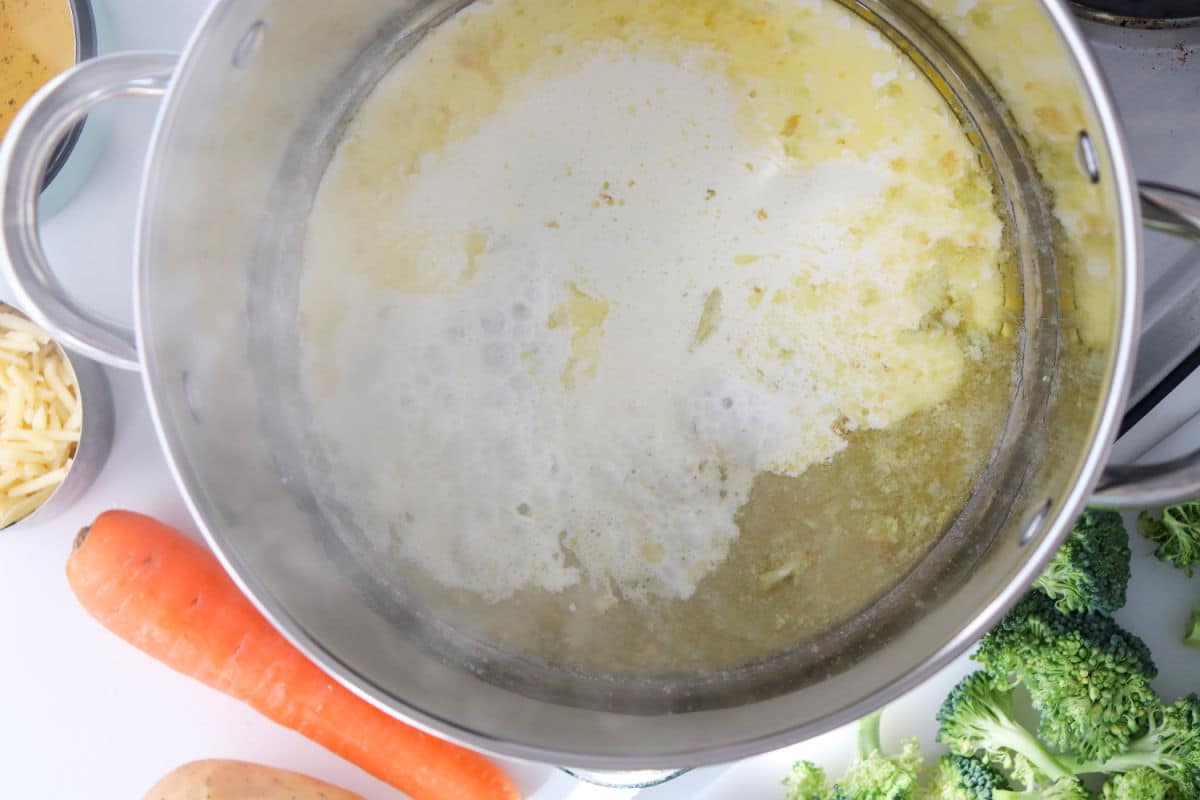 adding heavy cream to butter and garlic