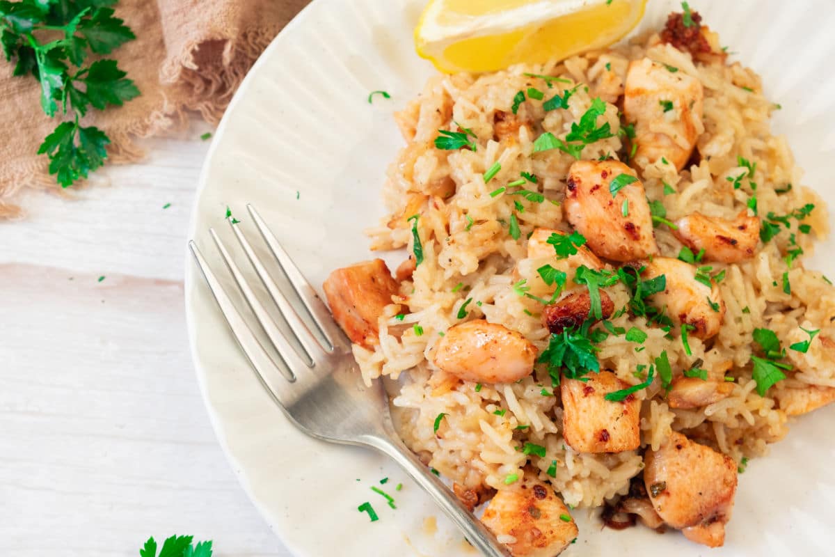 lemon chicken and rice on plate with fork