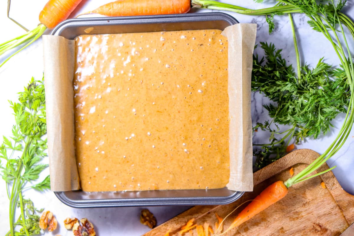 pouring carrot cake batter into pan