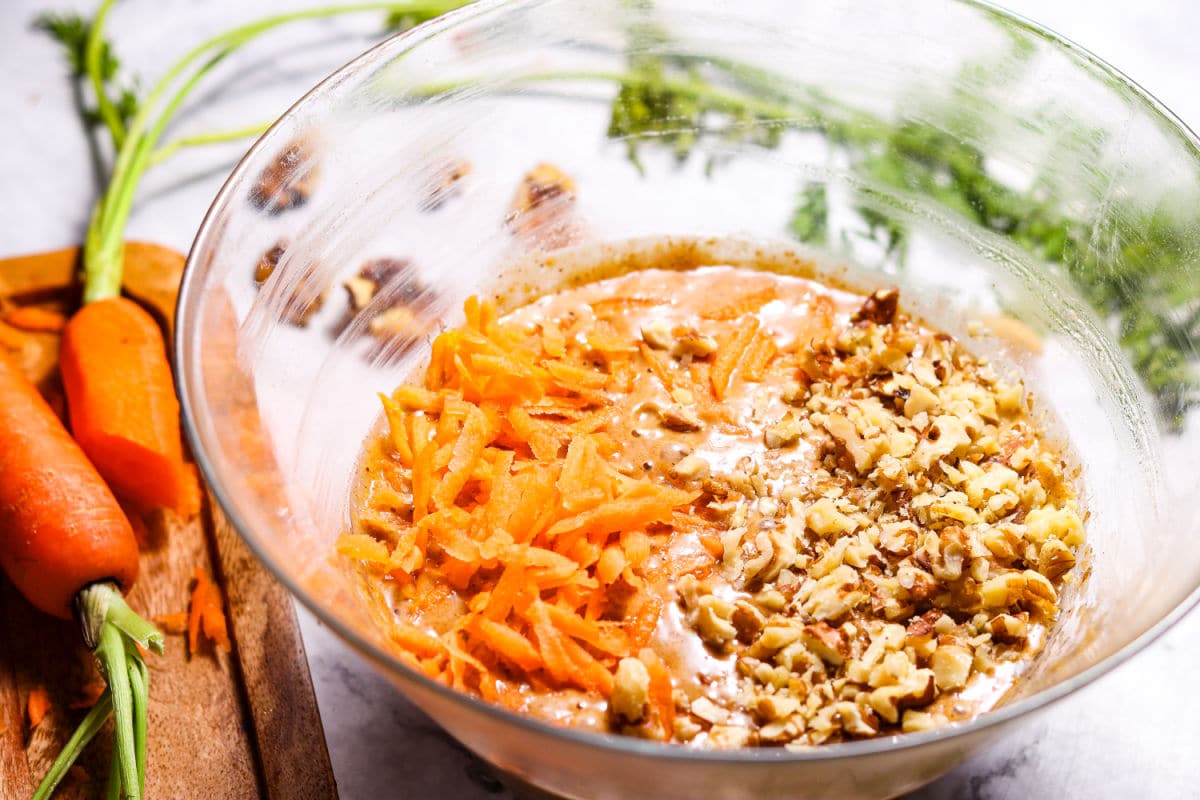 adding carrots and walnuts to carrot cake mix