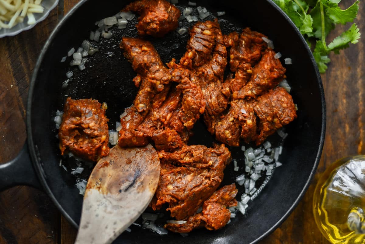 chorizo cooking in cast iron pan
