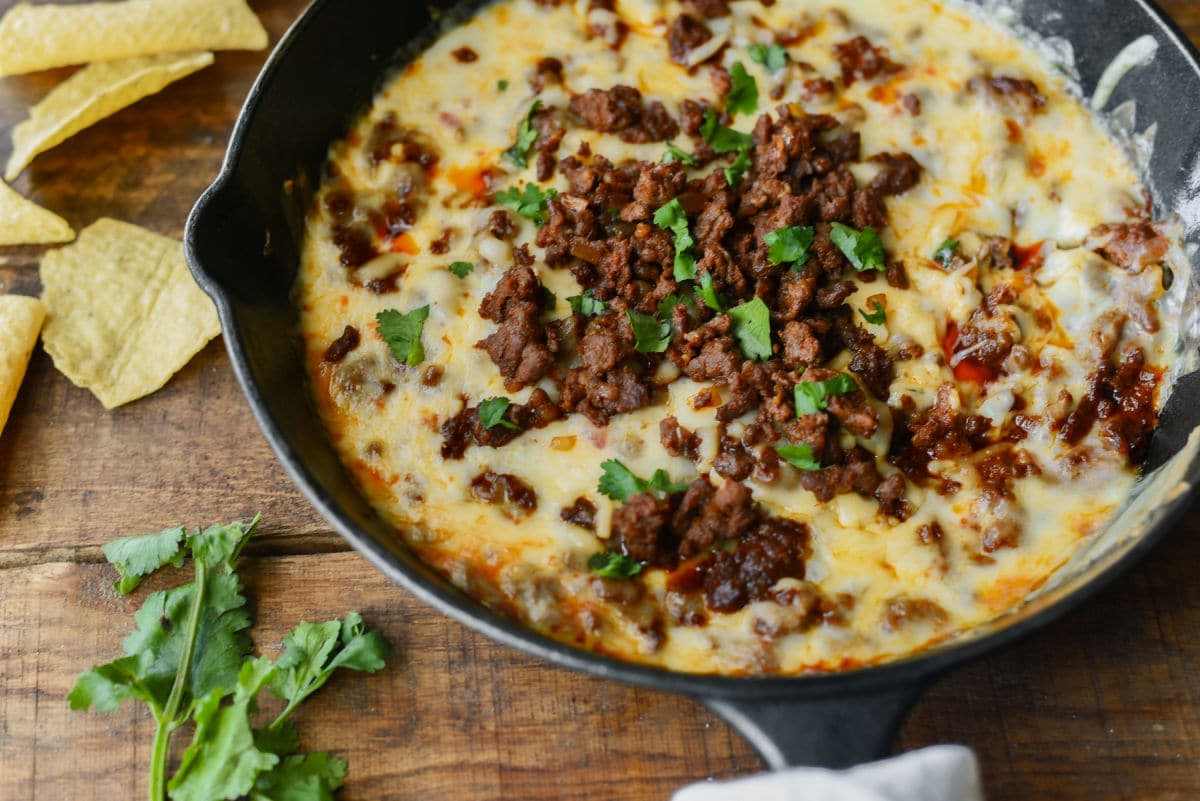 Queso Fundido baked in cast iron pan with chorizo and parsley