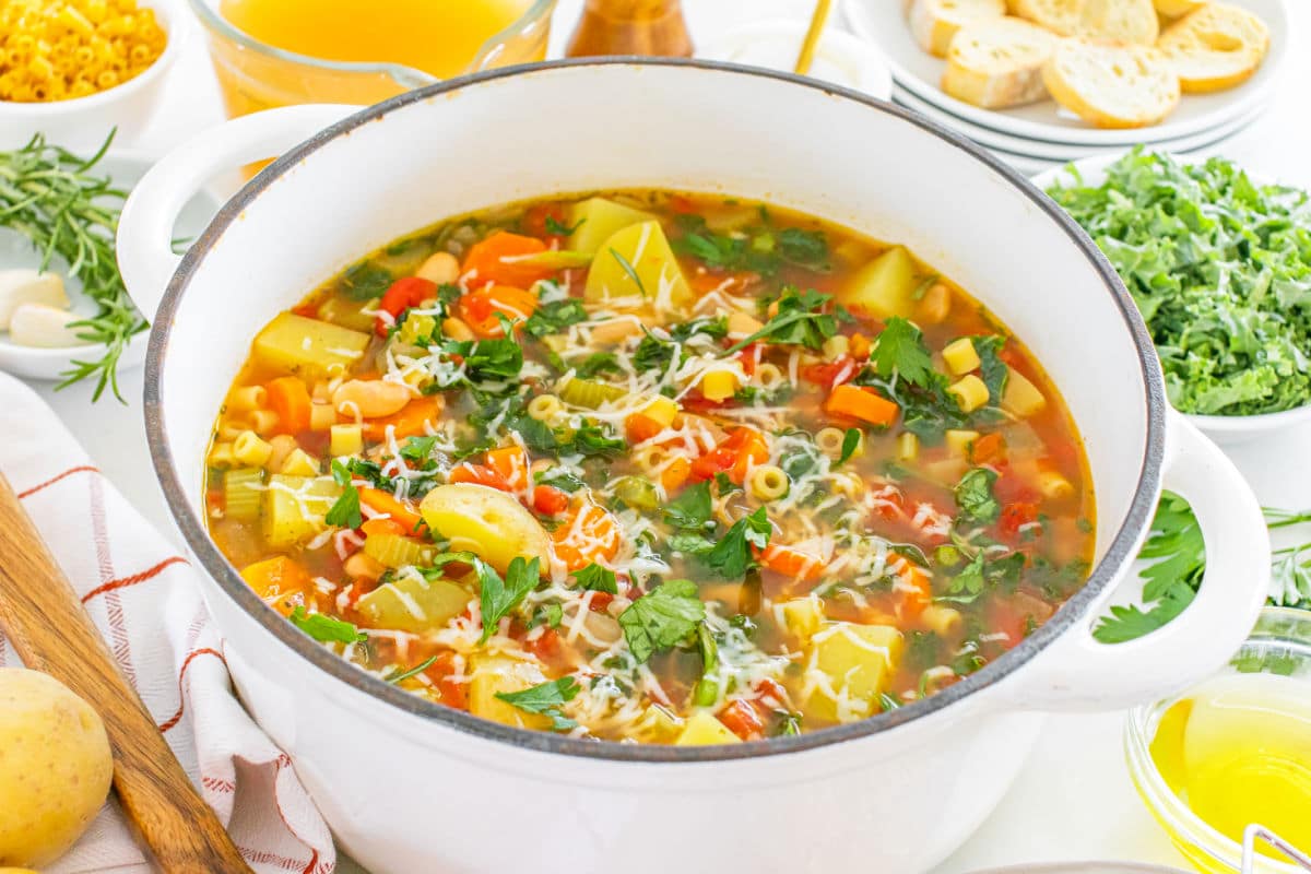 Garnishing minestrone with fresh parsley and shredded asiago